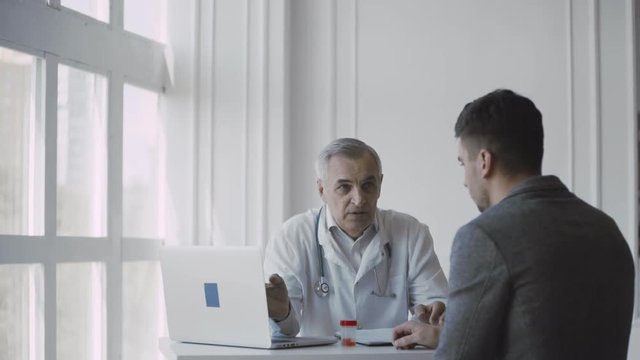 Senior doctor consults young patient