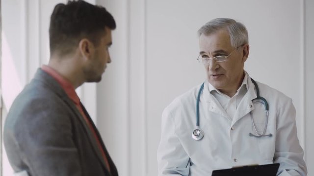 Senior doctor consults young patient