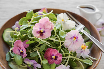 Sunflower sprouts, cucumber and edible flowers salad, vegan food © SewcreamStudio