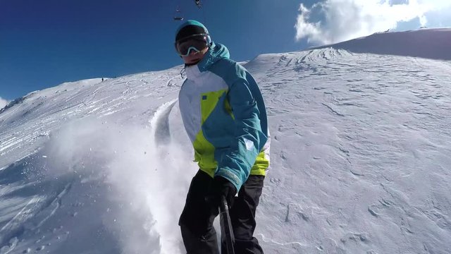 Snowboarder doing hand drags and powder turns in fresh snow
