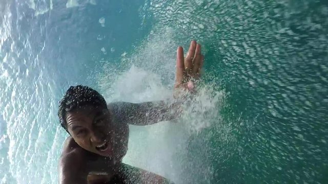 SLOW MOTION: Pro surfer surfing big tube wave and falls