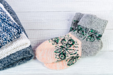 Wool socks and stack of various sweaters. Winter style. Isolated on white