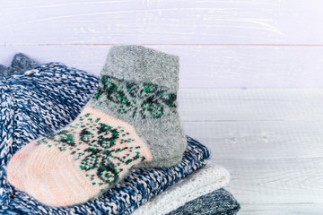 Wool socks and stack of various sweaters. Winter style. Isolated on white