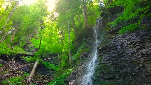 Waterfall in alpine forest over Partnach Gorge or Partnachklamm. Falls is a scenic location and nature attraction in Germany near Garmisch Paterkirchen. 