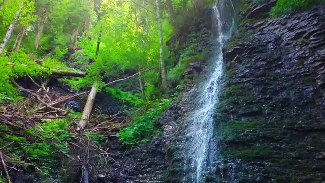 Waterfall in alpine forest over Partnach Gorge or Partnachklamm. Falls is a scenic location and nature attraction in Germany near Garmisch Paterkirchen. 