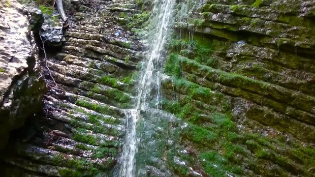 Waterfall in alpine forest over Partnach Gorge or Partnachklamm. Falls is a scenic location and nature attraction in Germany near Garmisch Paterkirchen. 