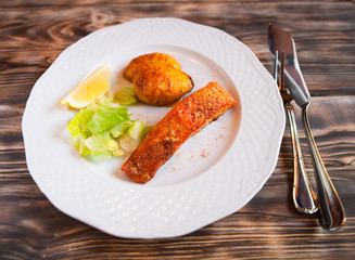 Grilled Salmon with potatoes, slice of lemon on wooden backgroun