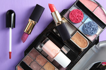 female cosmetic set on a purple wooden background