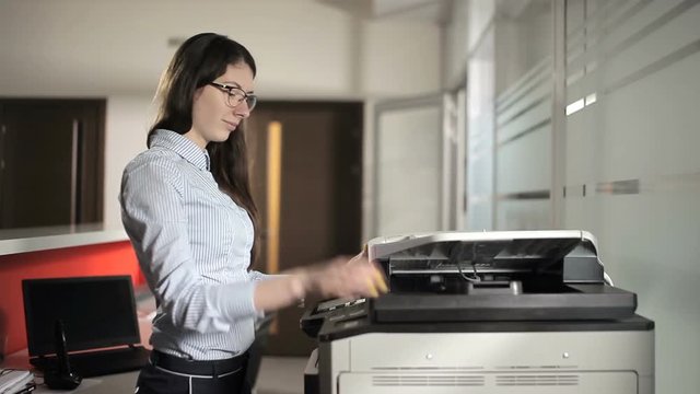 The young girl printing in the office