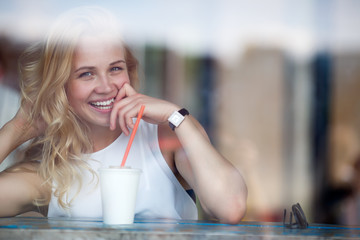 Beautiful blond woman having fun in caffee, closeup portrait