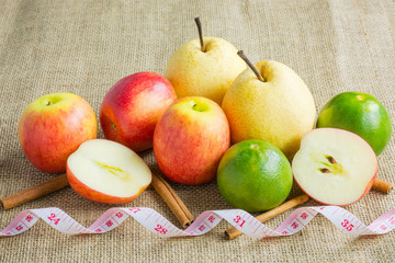 Group of mix fruits on hemp sack background. Red apple, orange (