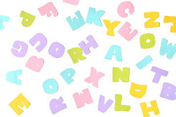 Scattered alphabet paper cut on white background