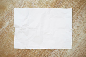 white crumpled paper on brown wood