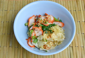 Chinese egg noodle with barbecue pork and dumpling on bowl