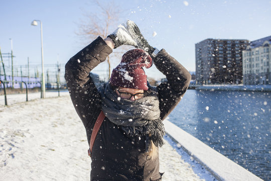 Woman playing with snow in city