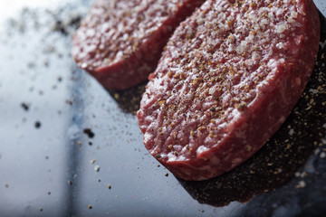 Meat for burgers, grilling, barbecue, bbq. Fresh, spicy, uncooked, delicious beef for hamburgers on dark background with copy space closeup