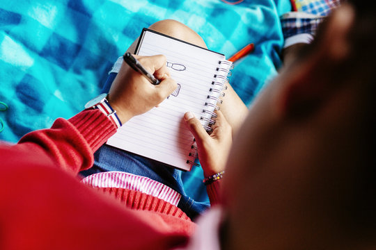 High angle view of university student writing in diary at park