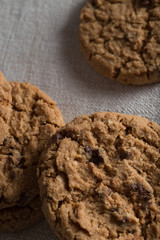 Cookies pile with chocolate chip on light textile background. Delicious morning snacks for breakfast, brunch and lunch. Appetizing, healthy, sweet, scrummy, and fast food.