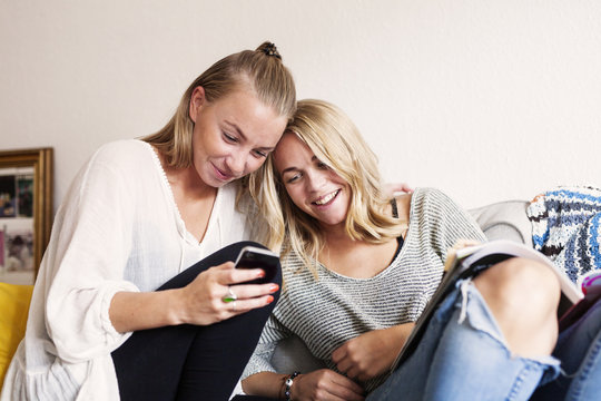 Two young women reading text message on smart phone