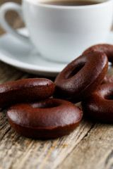 Chocolate vegetarian donuts with coffee for breakfast on wooden