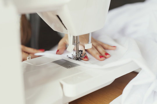 Cropped hands of fashion designer using sewing machine