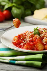 Serving gnocchi in tomato sauce with cheese.