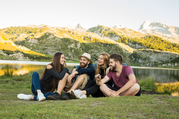 Group of four friends, boys and girls together in a lake smiling