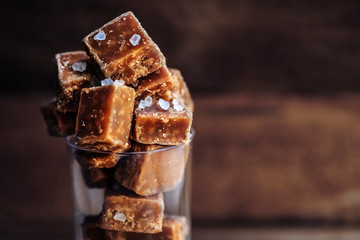 Salted caramel pieces and sea salt close up. Butter caramel cand