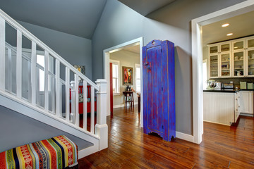 Hallway interior in American house. Hardwood floor and blue cabinet