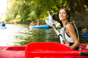 Brunette woman smiling in a canoe doing kayaking