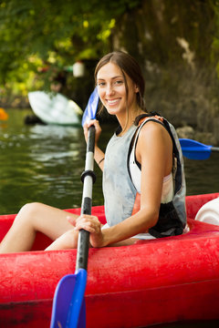 Brunette woman smiling in a canoe doing kayaking