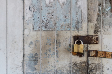 Old wooden door locked with golden padlock - Old town in Thailand