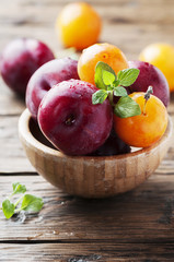 Sweet fresh black and yellow plums on the table
