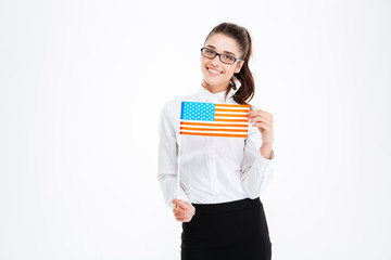 Cheerful attractive young businesswoman in glasses holding USA flag