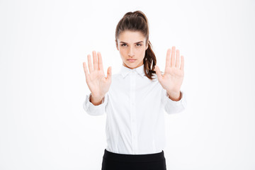 Serious beautiful young businesswoman showing stop gesture with both hands