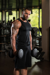 Fototapeta na wymiar Fitness Muscle Man Exercise Biceps With Dumbbells
