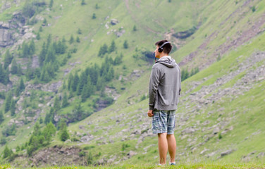 Naklejka premium Teenager man with headphones listen to music melacholic at mount
