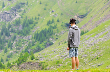 Naklejka premium Teenager man with headphones watching the mountains melacholic