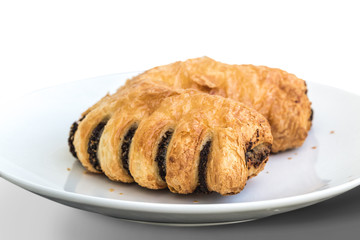 Puff pastry filled with poppy seed on white plate