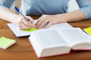 close up of student with book and notebook at home