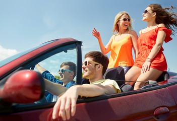 happy friends driving in cabriolet car