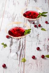 Sour cherry cocktail with fresh fruits on wooden background. Sweet and summer concept