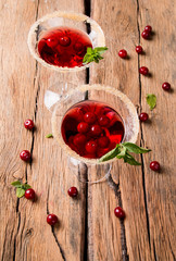 Sour cherry cocktail with fresh fruits on wooden background. Sweet and summer concept
