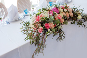 Flower arrangement on the table. Flowers and white tablecloth, wedding, roses, peonies
