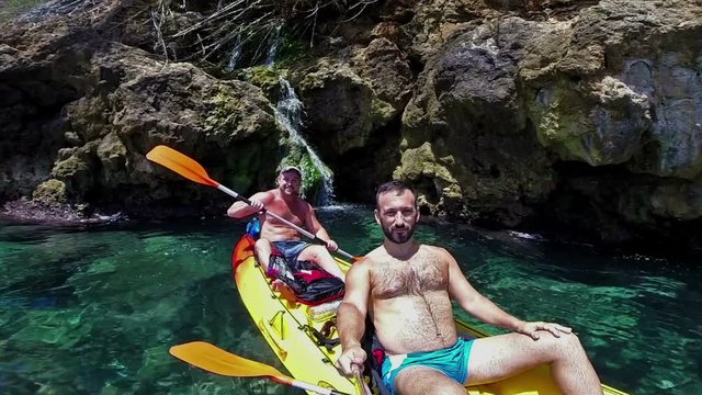Two men taking a selfie in a kayak.