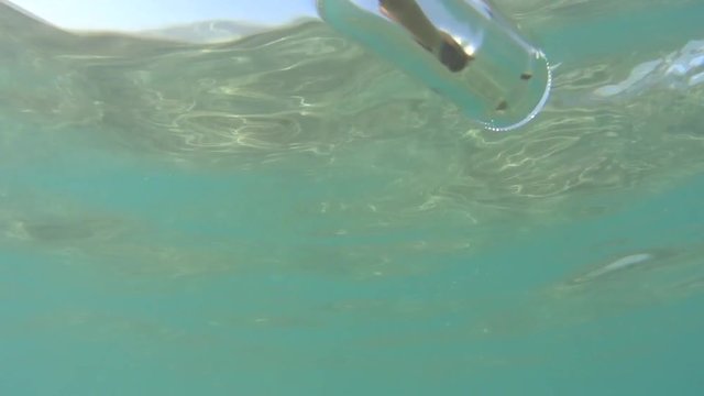 bottle with a message falls and floats in the sea