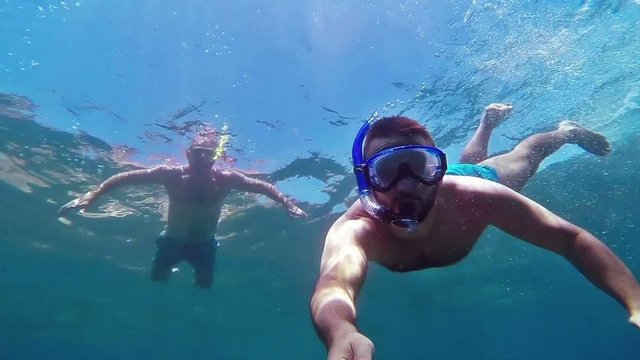Two men snorkeling. Slow motion