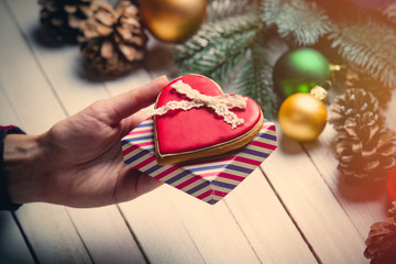 female hand holding a cookie and gift