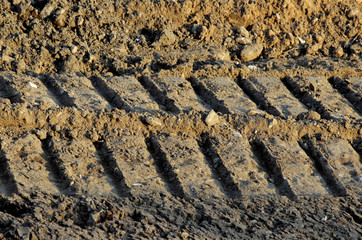 Wheel tracks in the mud, detail footprints bulldozer in the construction road © wolfness72
