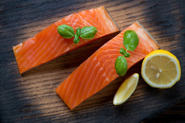 Closeup of sliced smoked trout fillet with lemon and basil